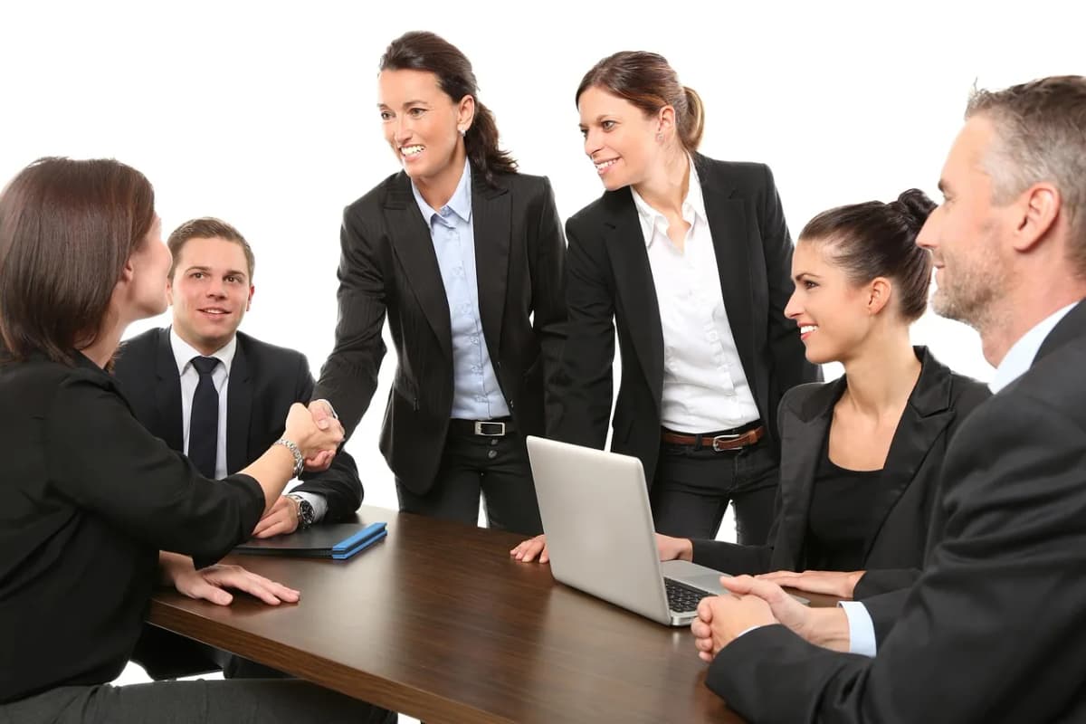Two people shaking hands in an office, as employers return to in-person interviews