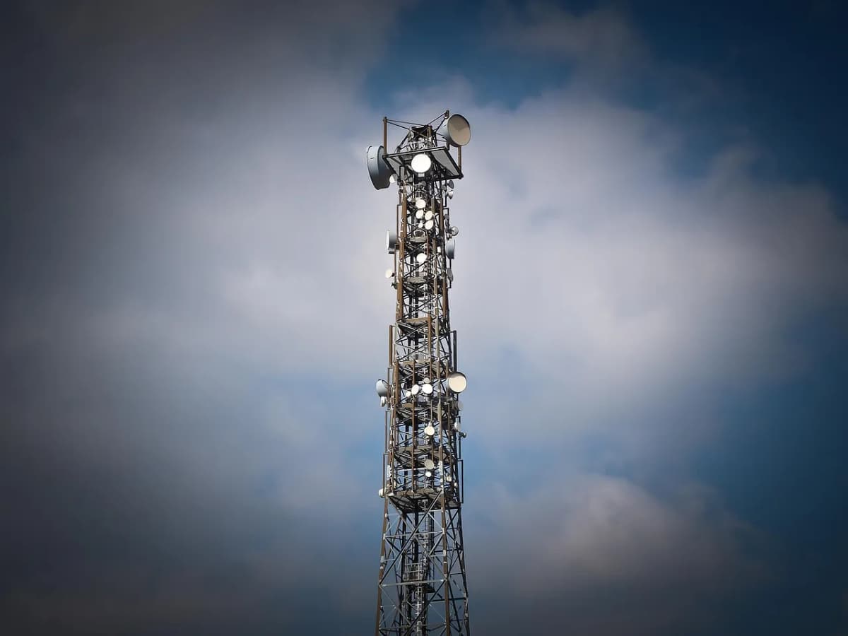 Telecommunications tower with antennas against a cloudy blue sky