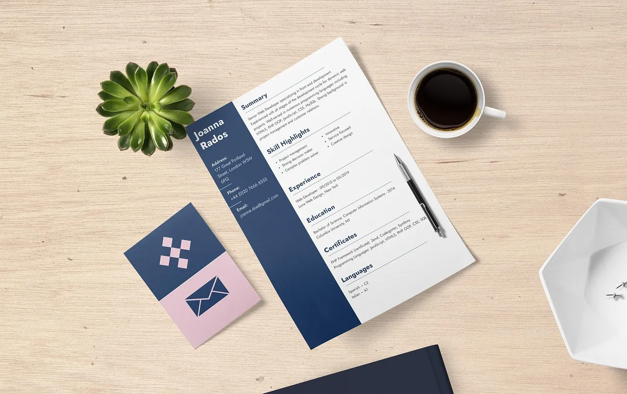 English resume template with a navy sidebar, summary, skills, experience and education sections on a desk beside a coffee cup and a succulent