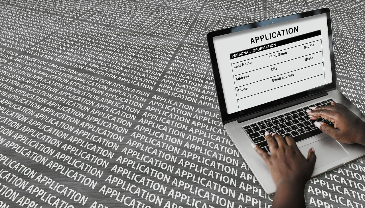 Hands typing on a laptop keyboard while editing a resume