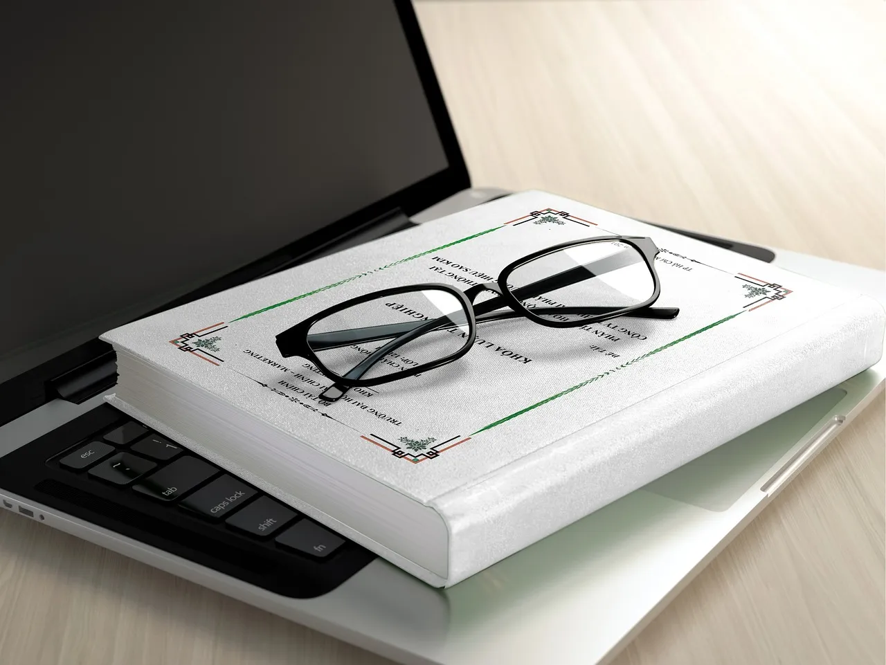 Reading glasses resting on a certificate folder on top of a laptop