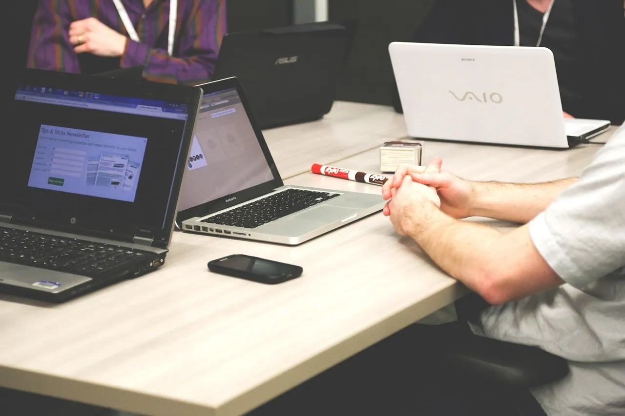 People working on laptops around a shared office table