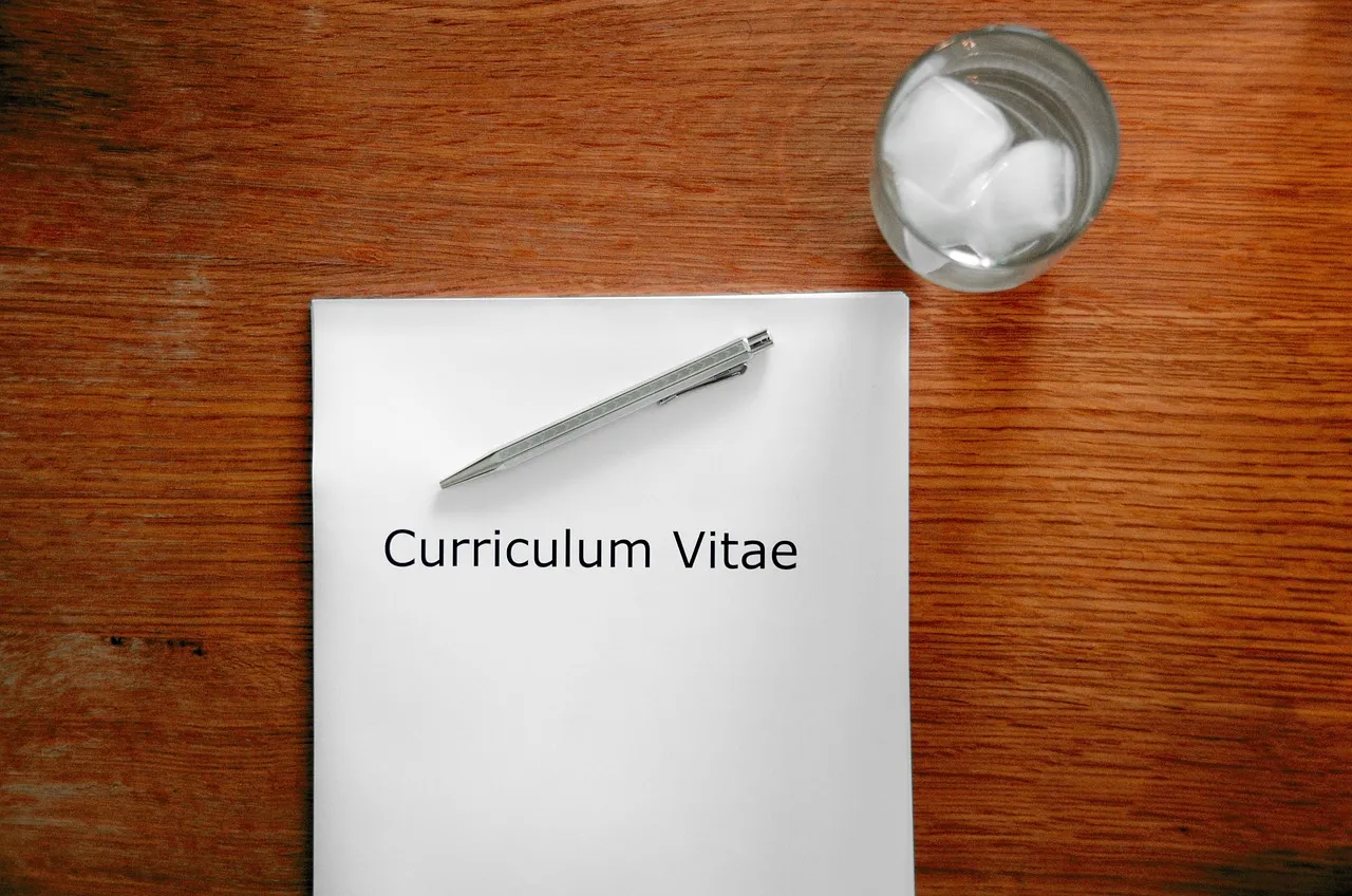 Printed resume on a desk next to a pen and laptop, ready for an interview