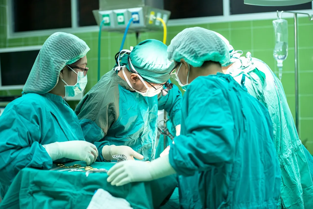 Surgical team in green scrubs and masks operating in a hospital theatre
